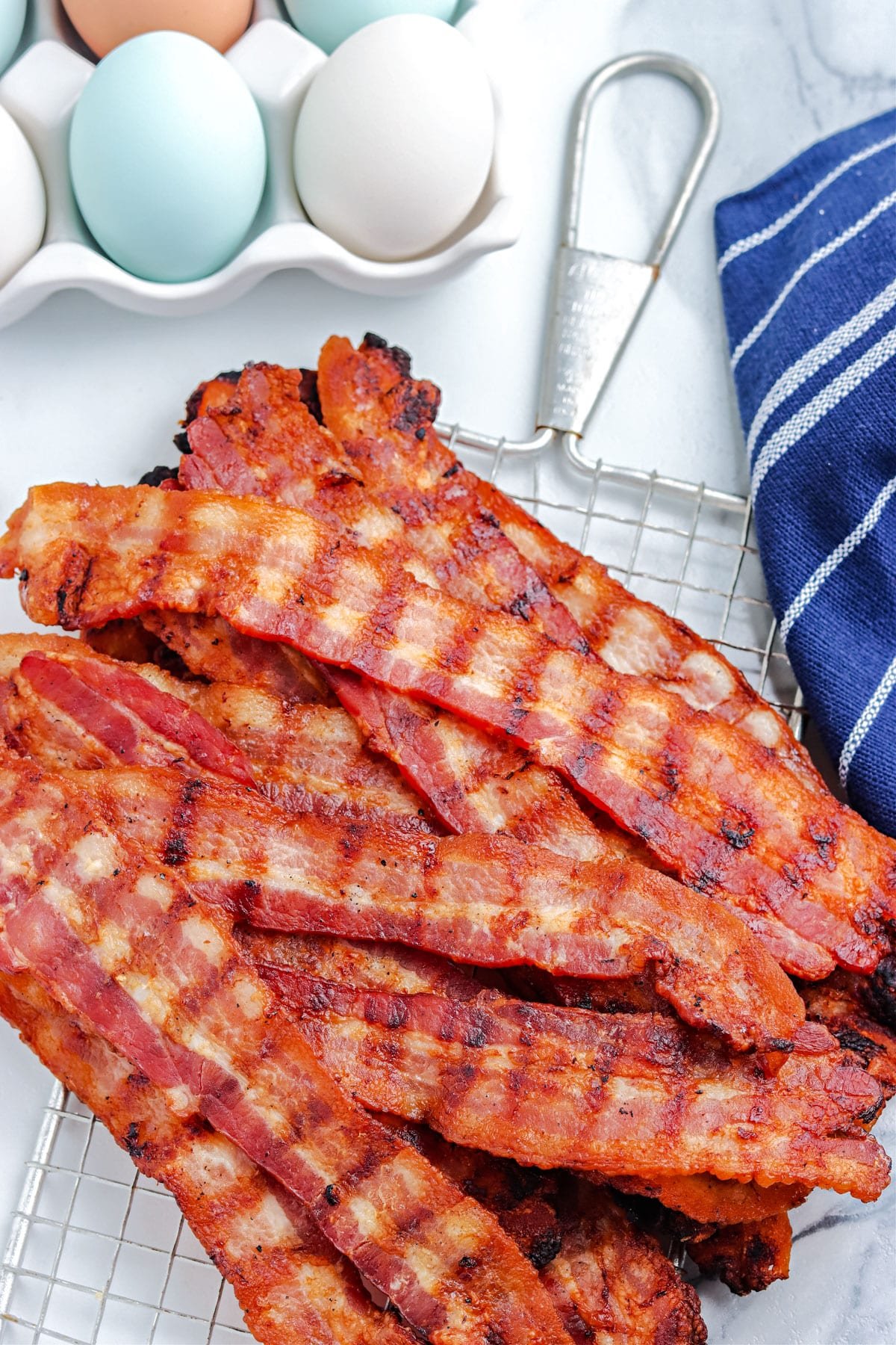 A pile of Grilled Bacon on a serving board.