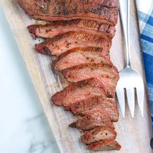A close up picture of sliced Smoked Tri Tip steak on a cutting board.