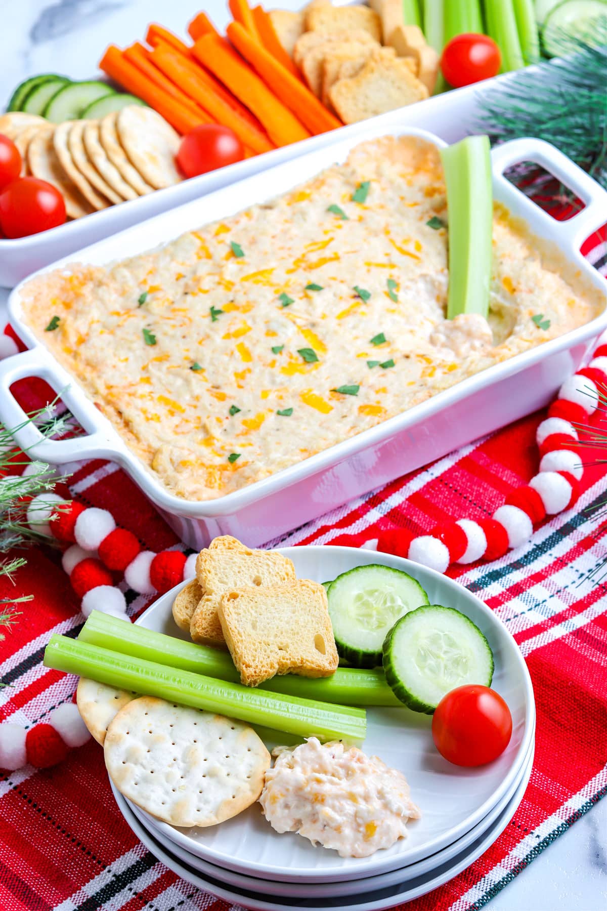 Some of the finished Crab Dip on a white plate along with dippers.