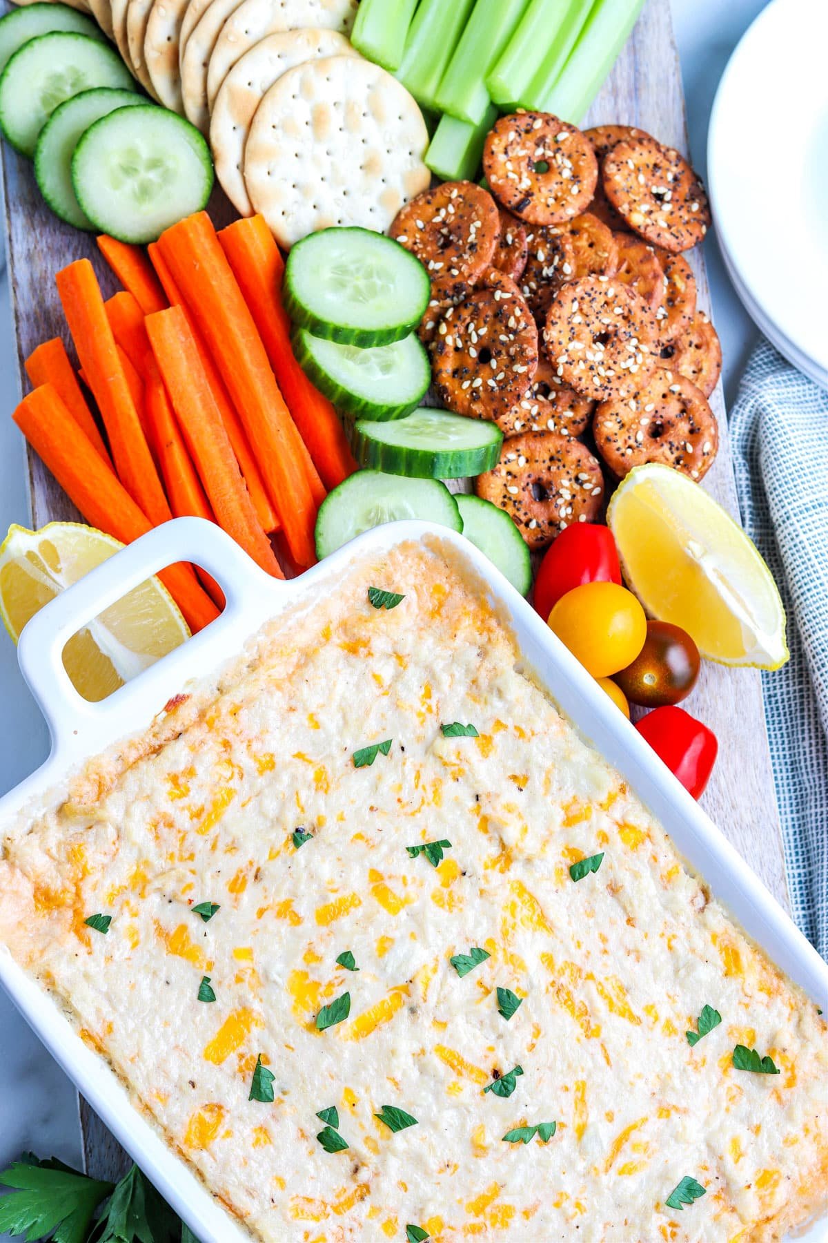 An overhead picture of the finished Hot Crab Dip with carrots, cucumber, pretzels, and crackers surrounding it.