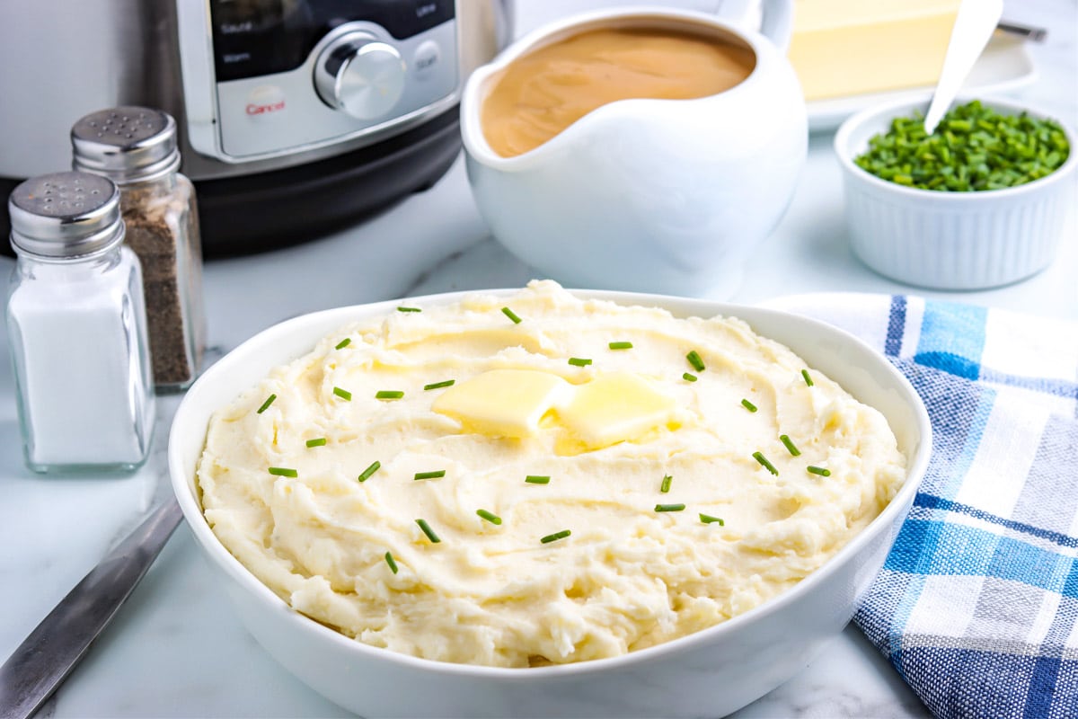 The finished Instant Pot Mashed Potatoes recipe in a white serving bowl.