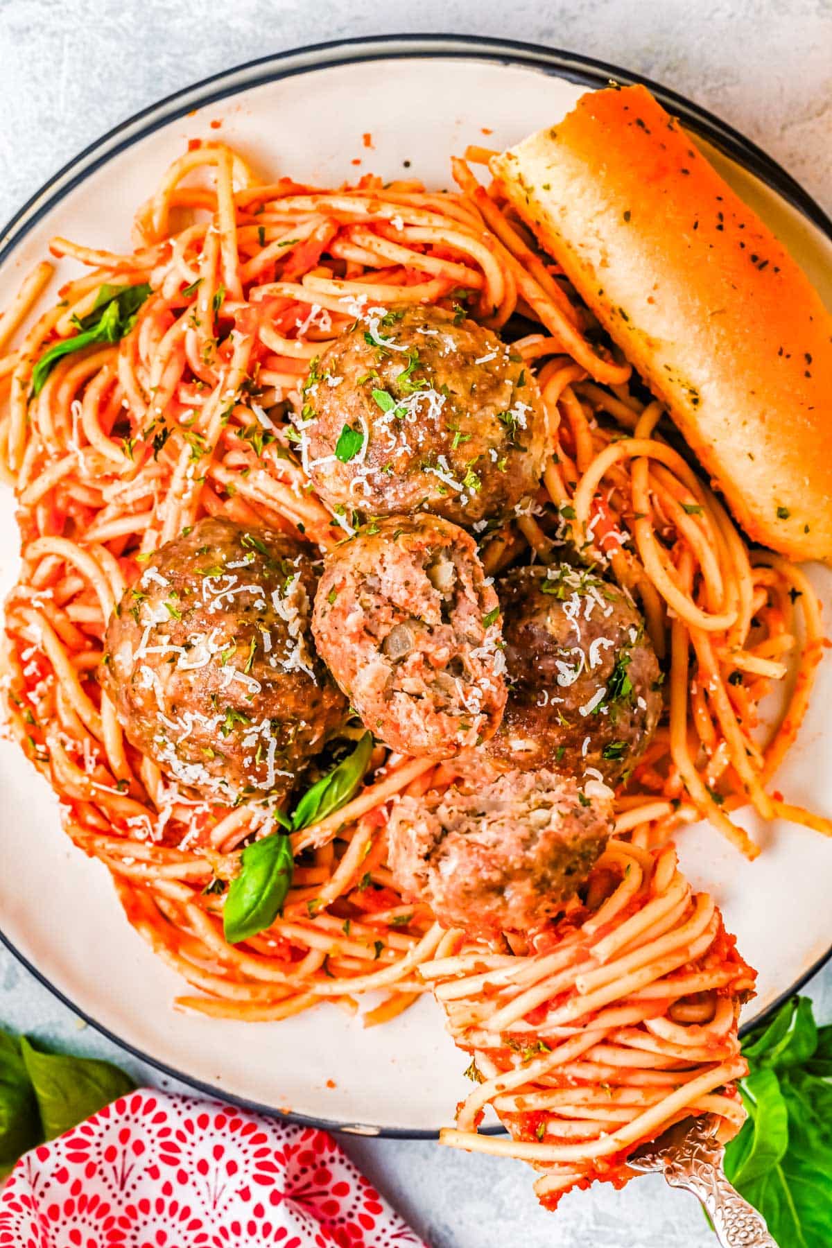 An overhead picture of Italian Meatballs on top of spaghetti with tomato sauce.