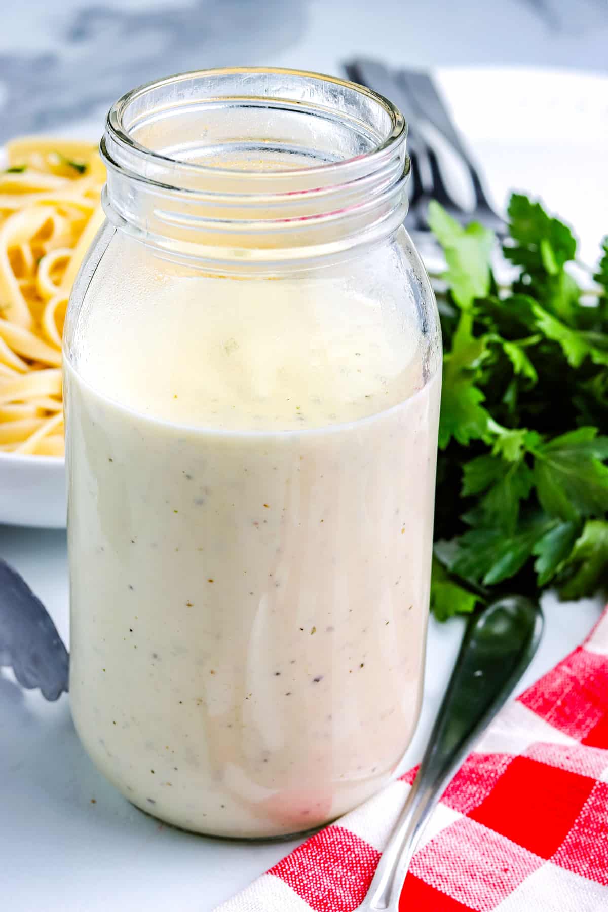 The finished Gluten Free Alfredo Sauce in a glass jar.