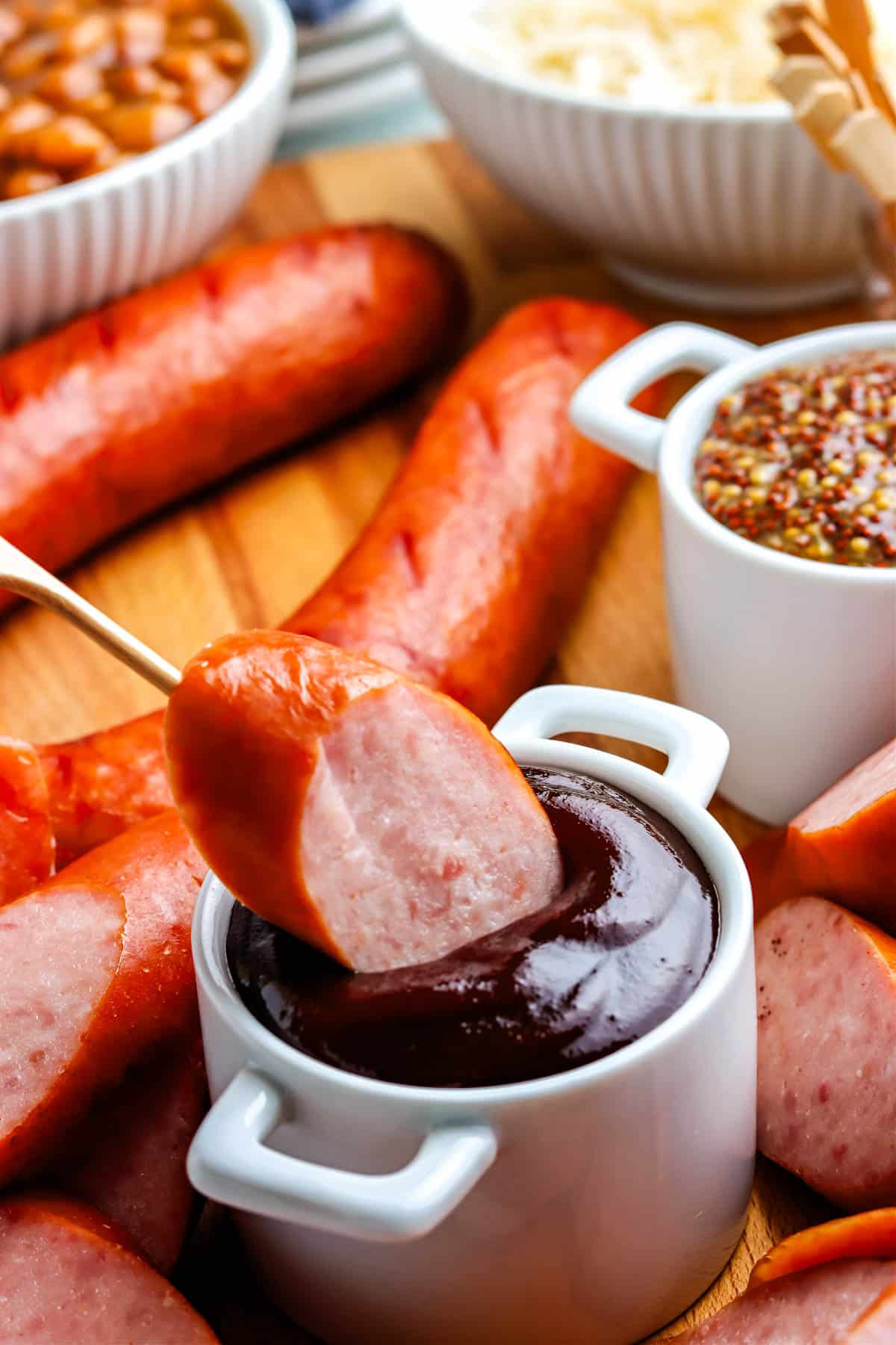A piece of the finished Smoked Kielbasa recipe dipped into sauce.