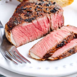 A filet mignon cut into so you can see the juicy, pink interior.