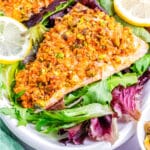 Salmon on a plate with lemon slices.