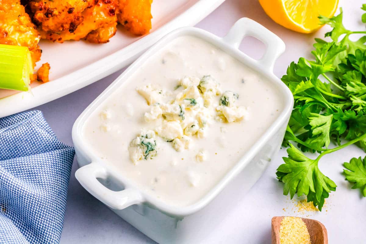 Dressing in a white serving dish and garnished with blue cheese.