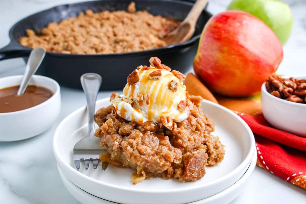 Apple crisp that's been smoked and dished onto a white dessert plate.