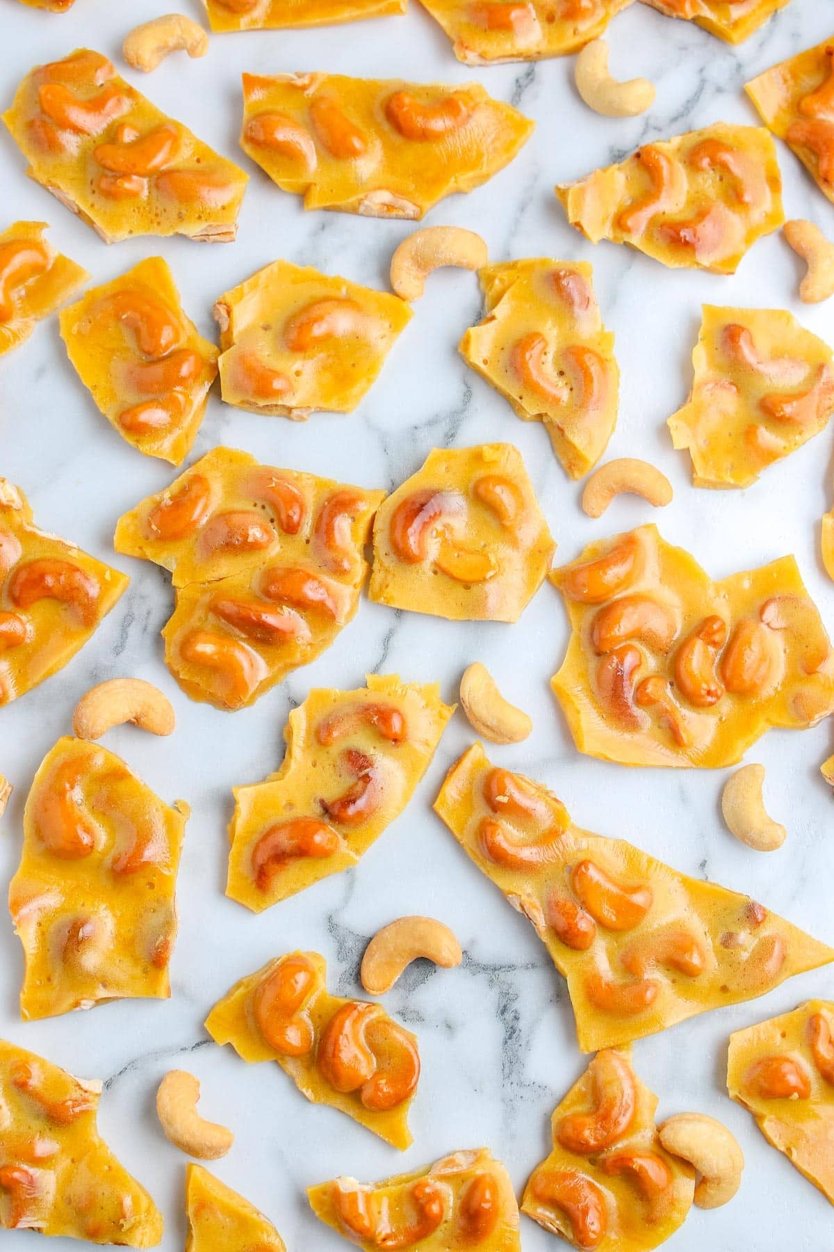 Cashew Brittle on a countertop, broken into pieces.
