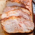 Slices of pork loin on a wooden cutting board.
