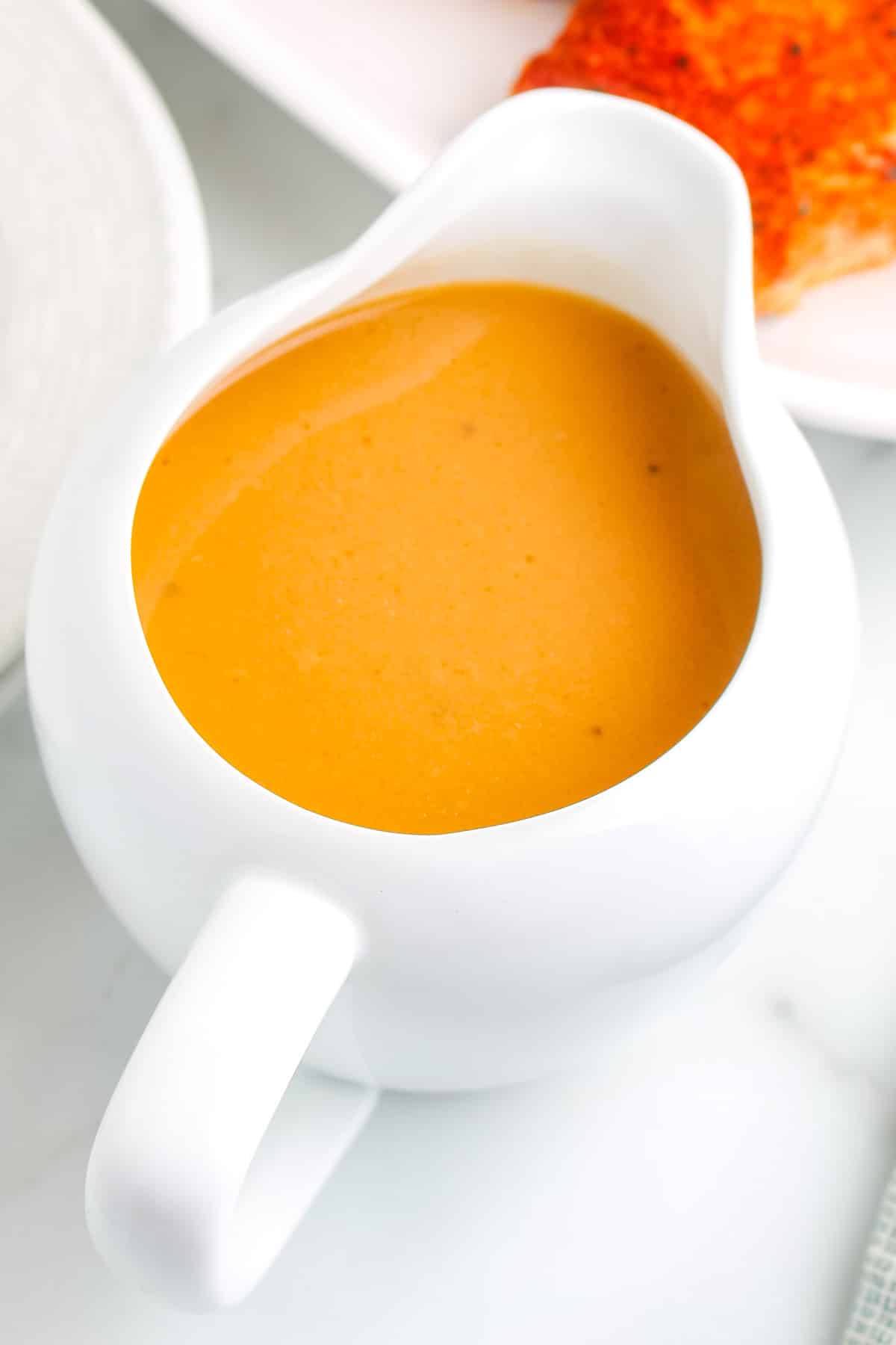 Gravy in a white gravy boat.