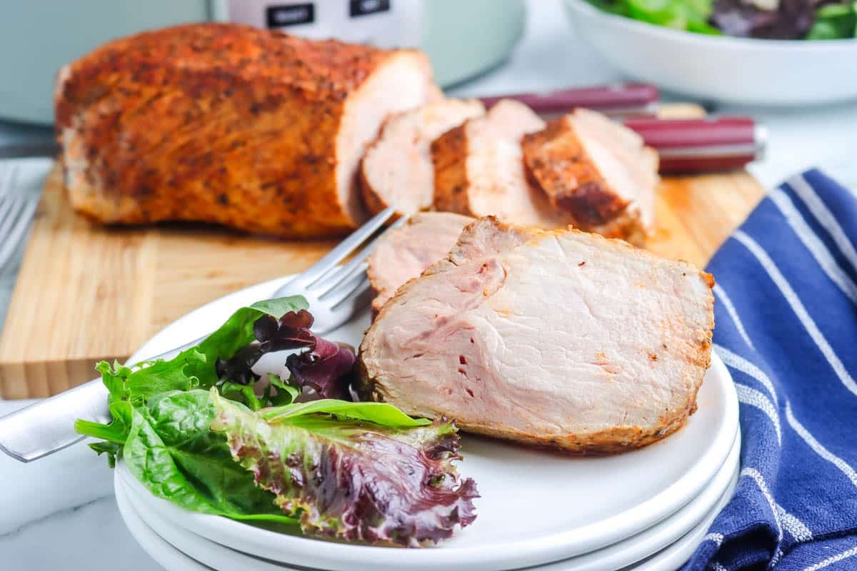 Slices of pork on a white plate. 