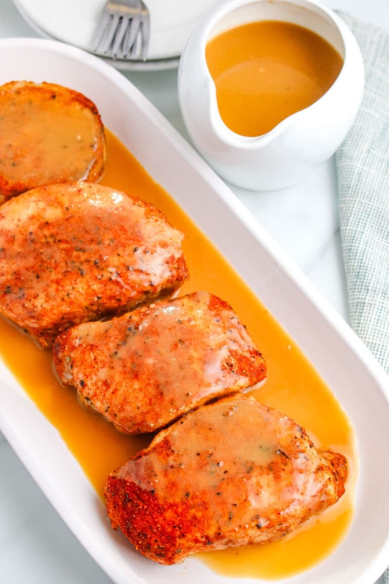 Pieces of pork on a platter with pork meat gravy poured over them.