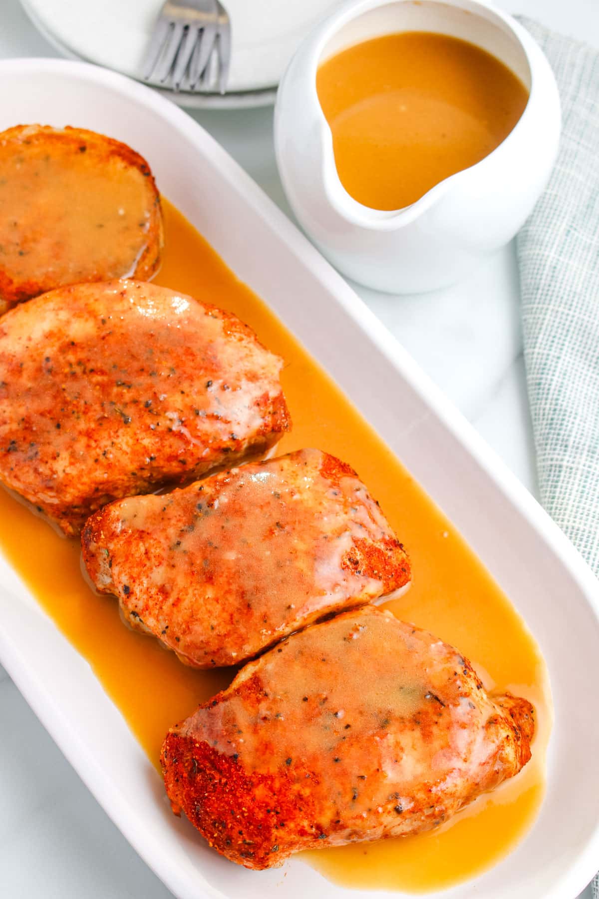 Pieces of pork on a platter with pork meat gravy poured over them.