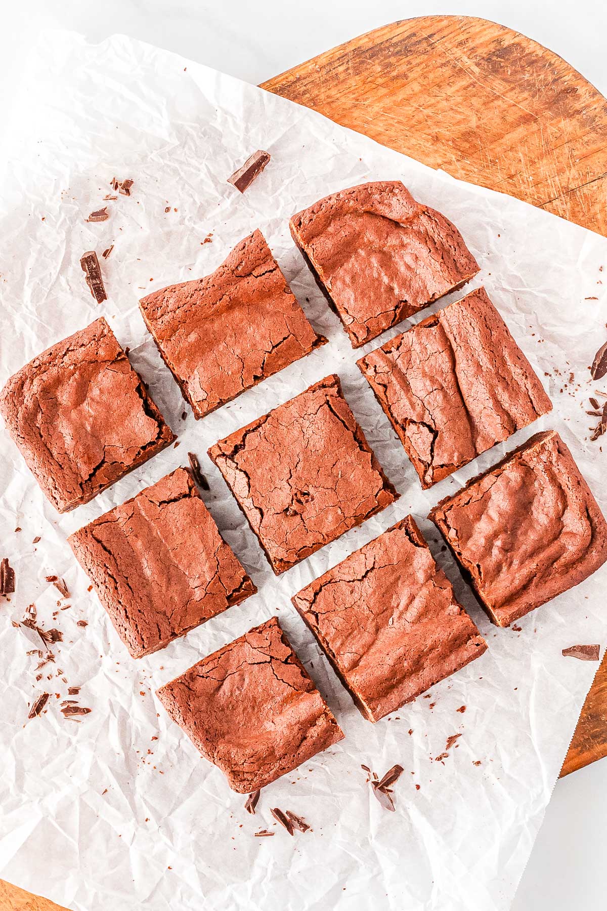 The fudge brownies on a wooden cutting board and cut into nine squares.
