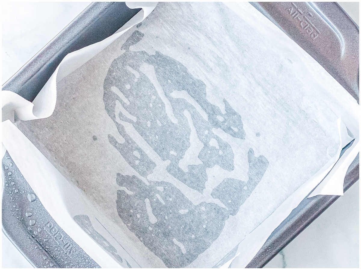 An 8 inch square baking dish lined with parchment paper and lightly sprayer with nonstick cooking spray.