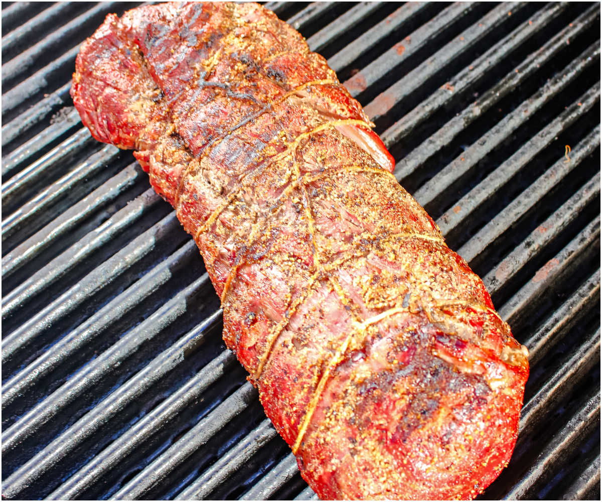 The beef tenderloin on a grill after it's been seared.