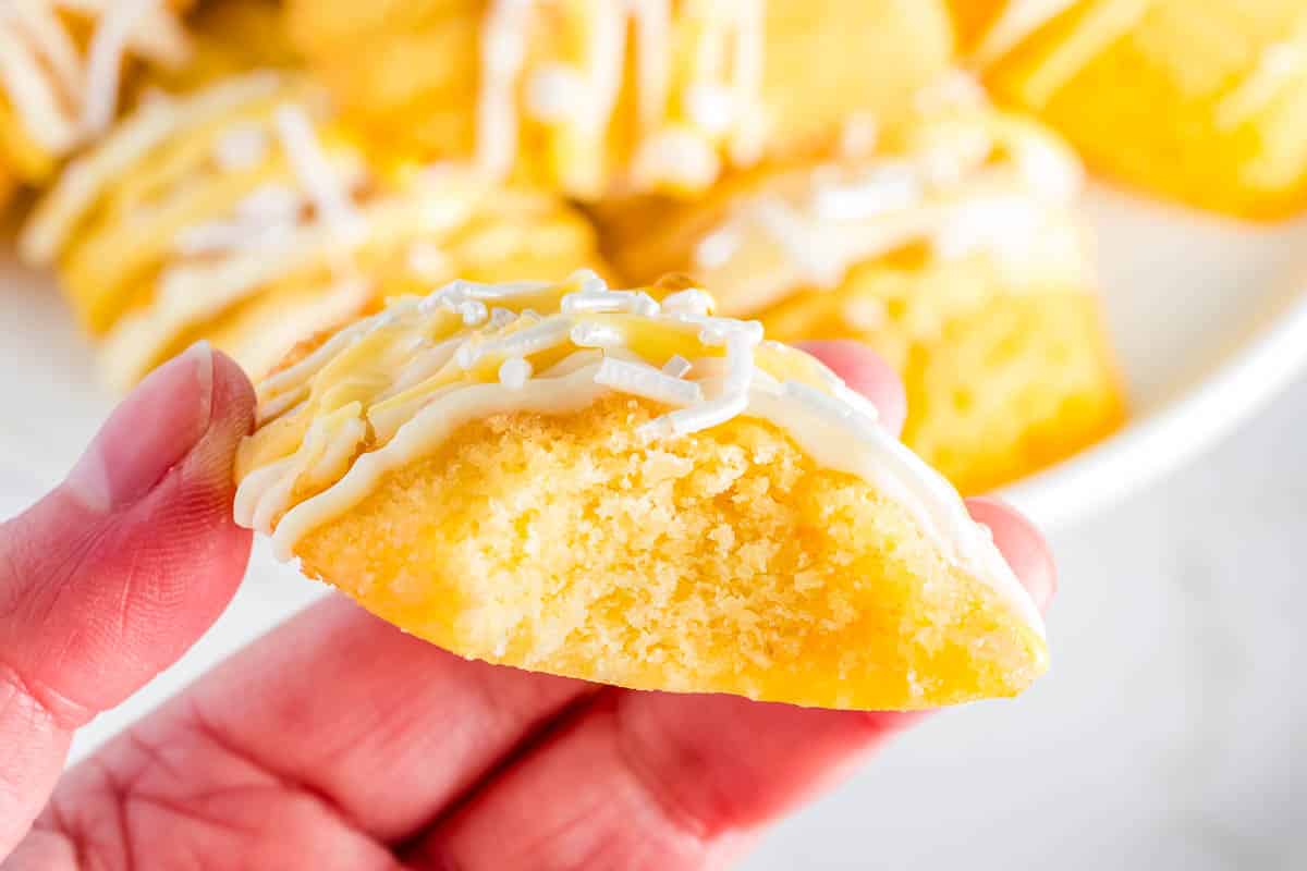 A madeleine with a bite taken out of it so you can see the buttery, tender interior.