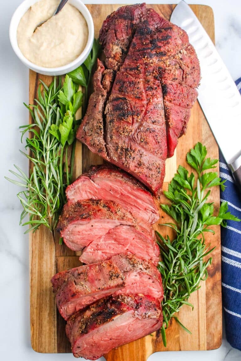A Smoked Beef Tenderloin on a wooden cutting board.