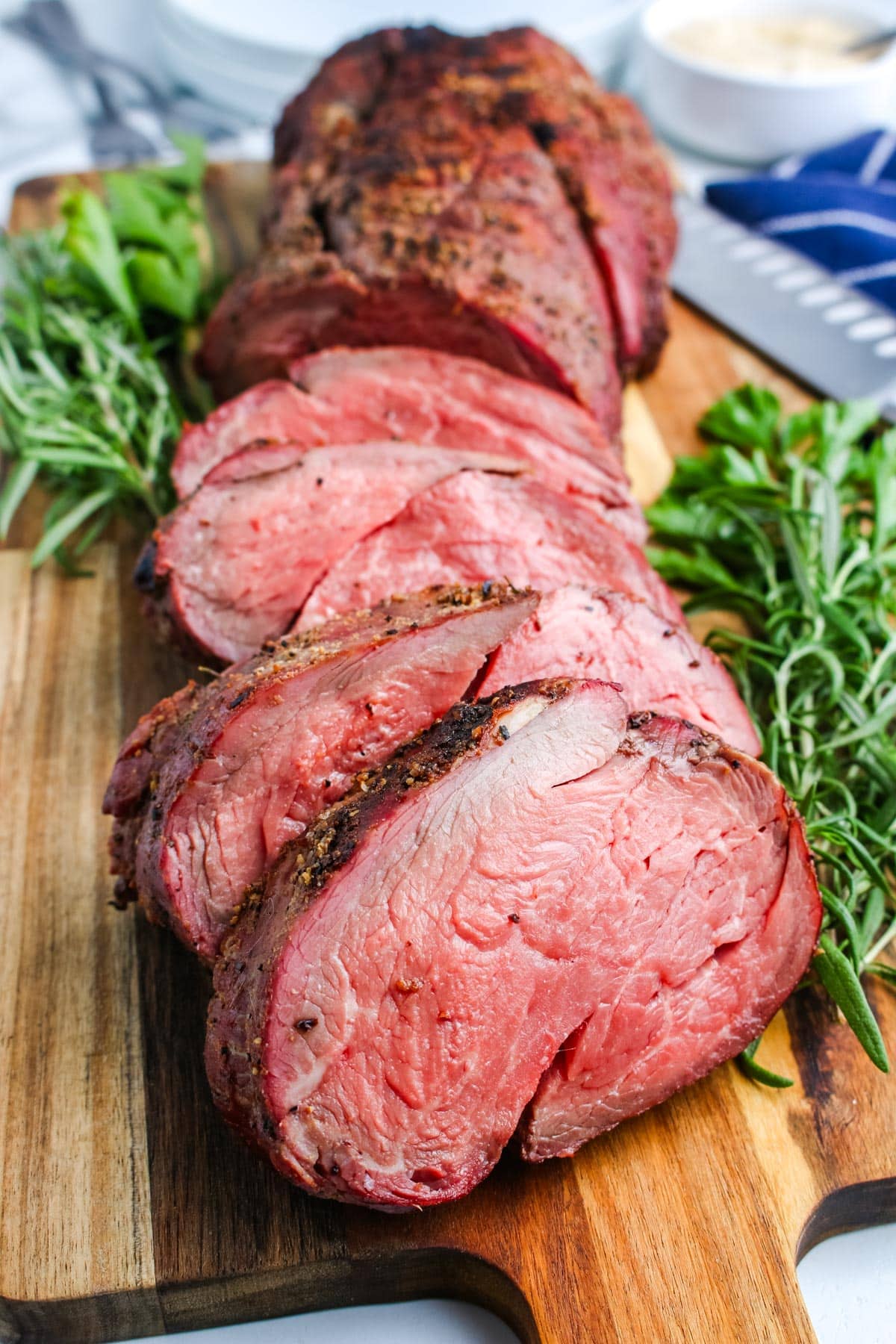Slices of beef tenderloin on a wooden cutting board.