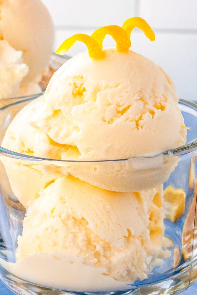 Three scoops of lemon sherbet in a clear class dish.