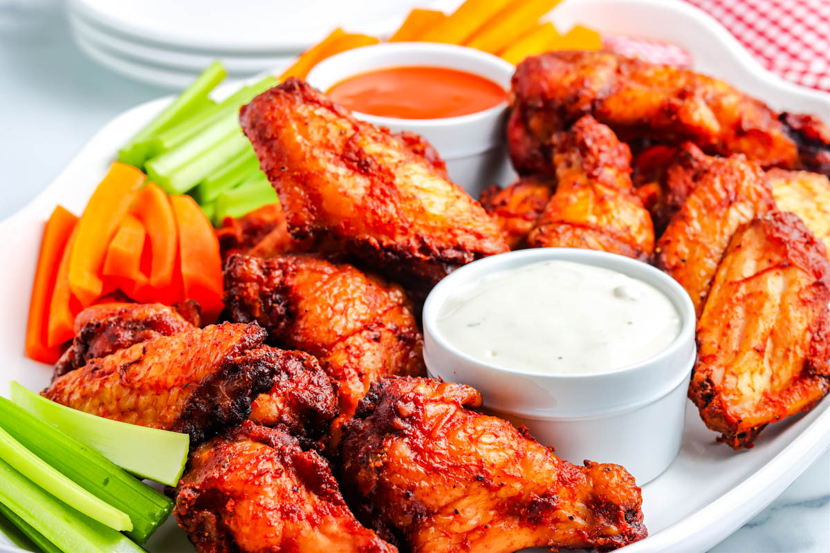 crispy smoked chciken wings on a white serving platter.