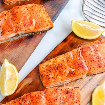 An overhead picture of four grilled cedar plank salmon filets.