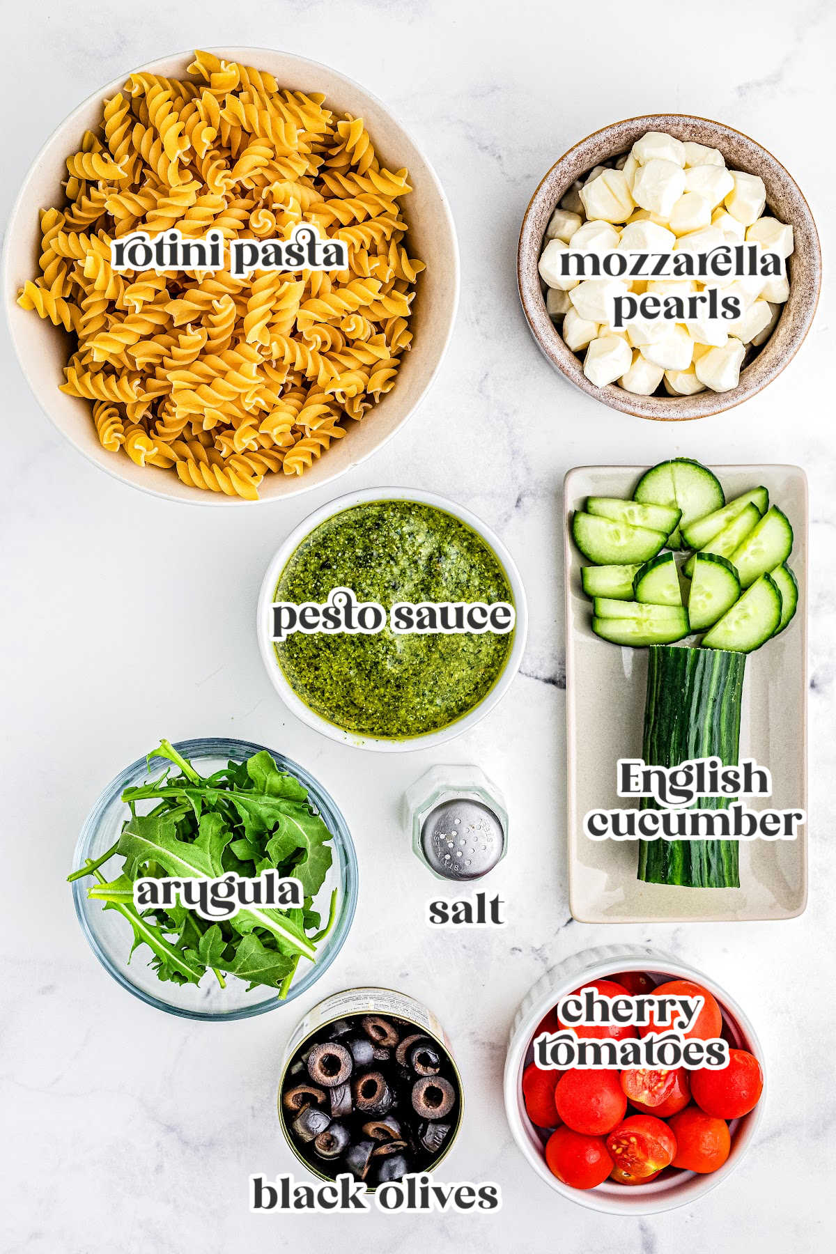 The Pesto Pasta Salad recipe ingredients with text overlay labeling each one.