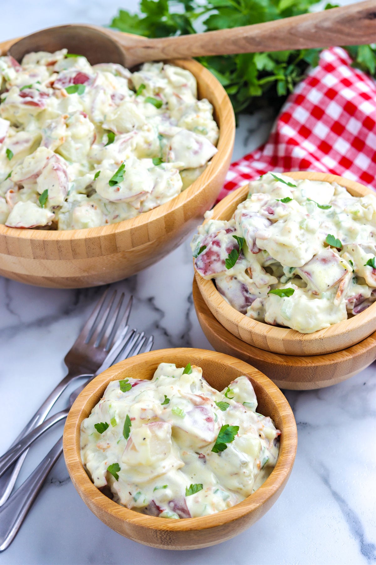The finished potato salad recipe without eggs in a serving bowl and in individual bowls.