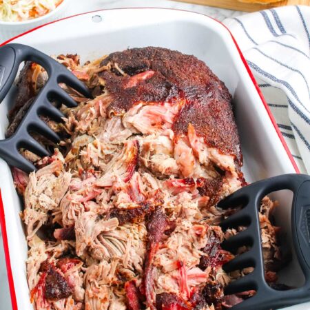 The smoked pulled pork in a pan after it's been pulled apart.