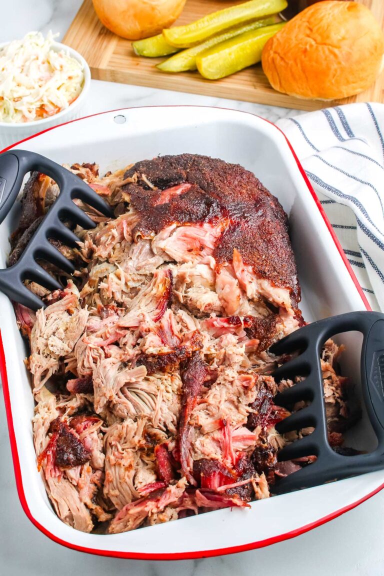 The smoked pulled pork in a pan after it's been pulled apart.