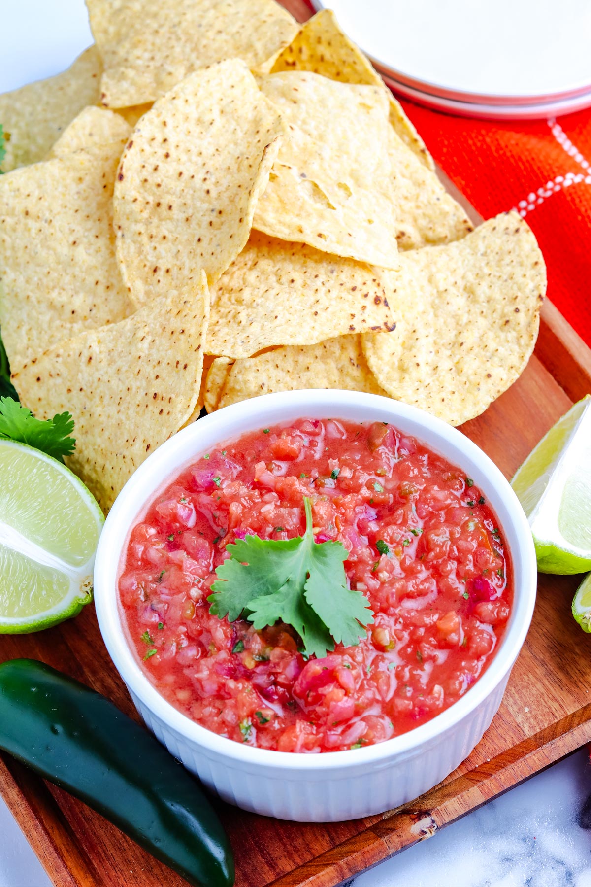 The finished smoked salsa in a white serving bowl surrounded by torilla chips.