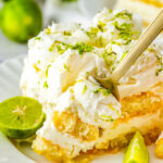 Plated slice showing creamy layers and lime garnish.