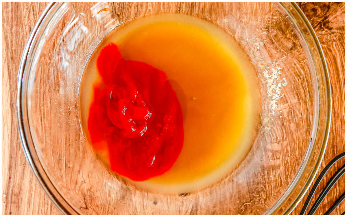 Ketchup and pineapple juice sit in a glass bowl ready to be whisked together for sweet and sour sauce.