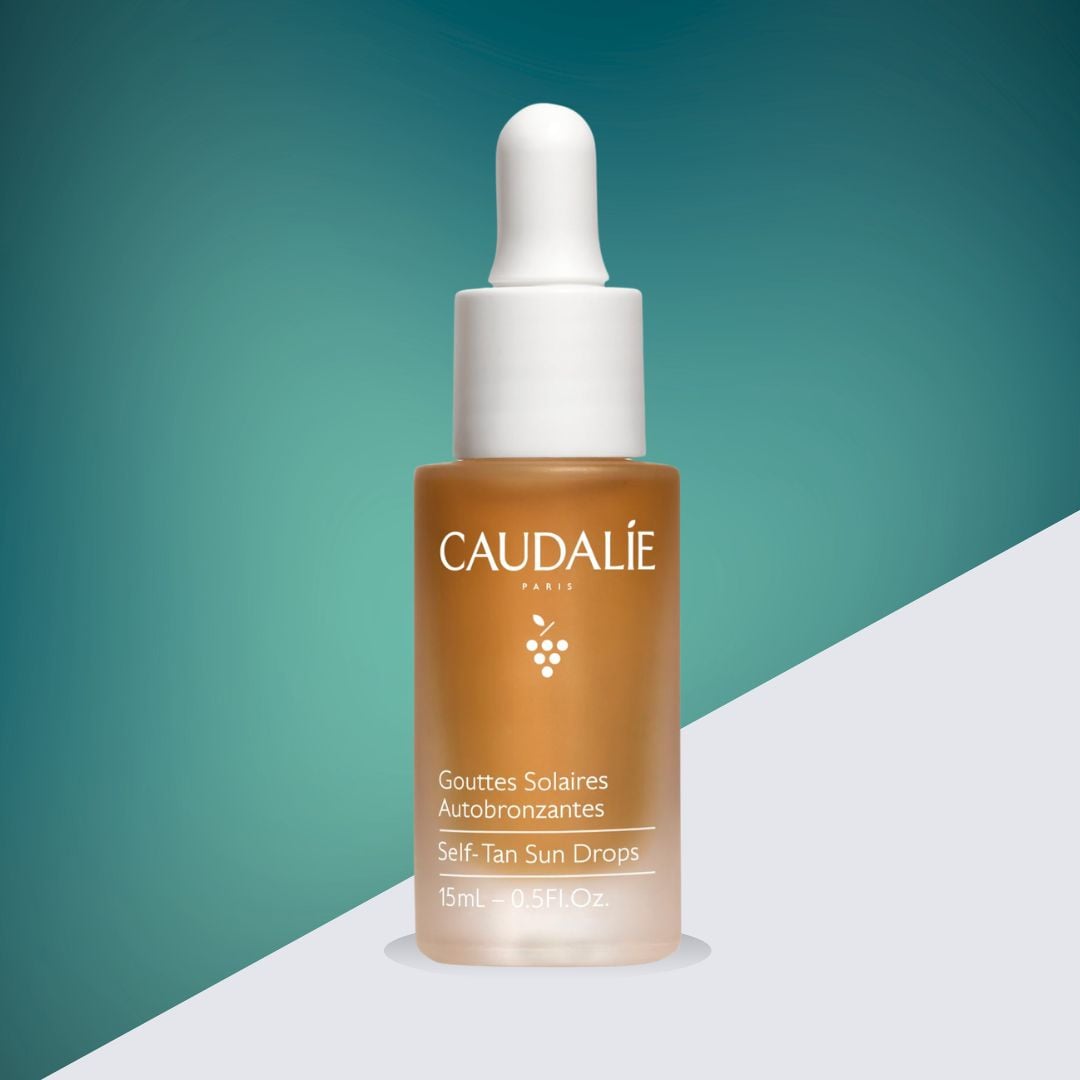 A bottle of Caudalie Vinoperfect self-tan sun drops on a teal background.
